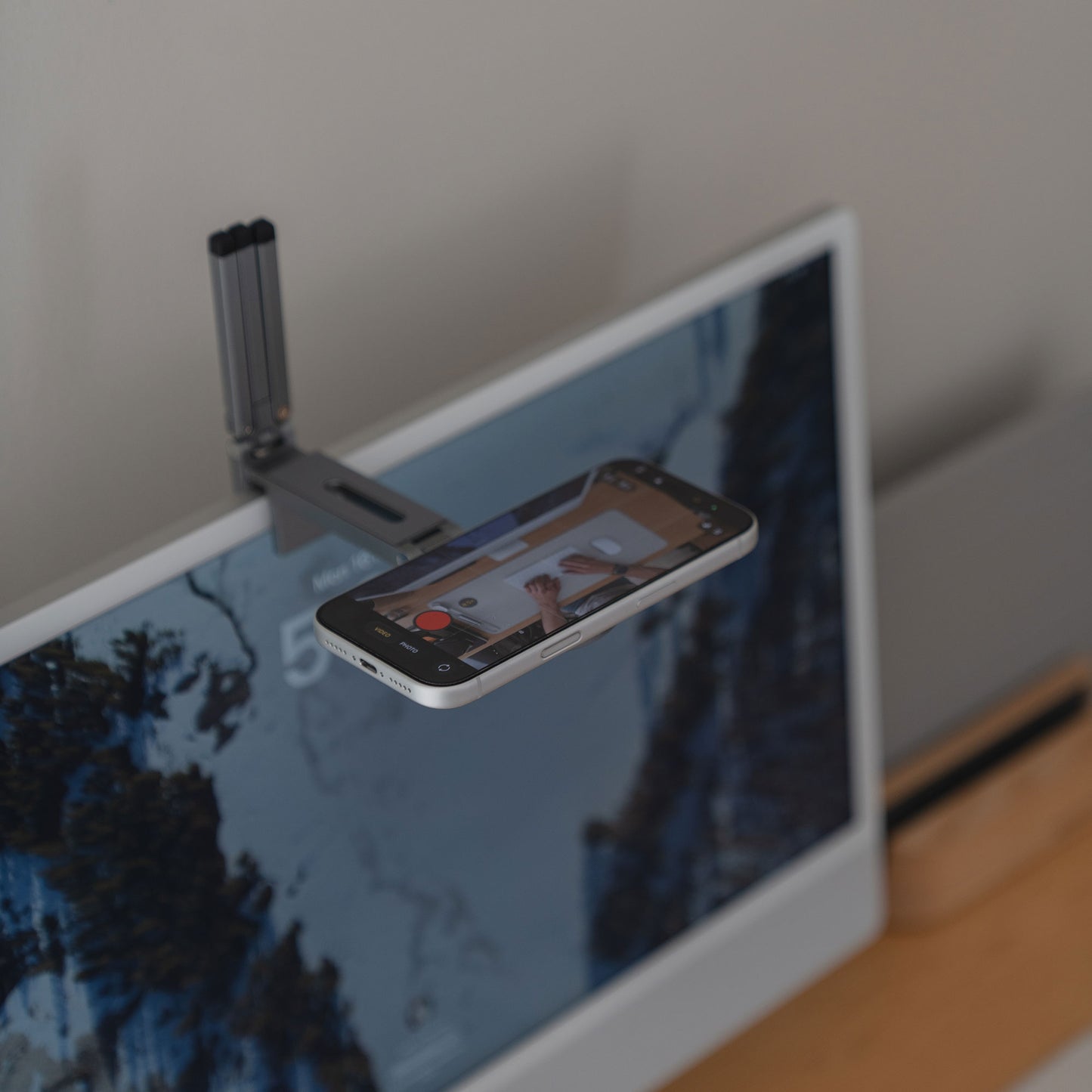 Die arktis iPhone MagSafe Tripod 360 Halterung von arktis wird über Ihrem Computerbildschirm befestigt und ermöglicht es Ihrem Smartphone, die Hände beim Schreiben auf einem Notizblock mit seinem um 360° drehbaren Design aufzunehmen.