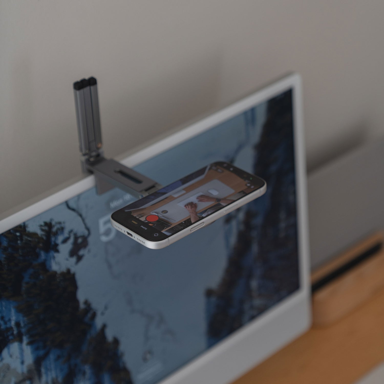 Die arktis iPhone MagSafe Tripod 360 Halterung von arktis wird über Ihrem Computerbildschirm befestigt und ermöglicht es Ihrem Smartphone, die Hände beim Schreiben auf einem Notizblock mit seinem um 360° drehbaren Design aufzunehmen.