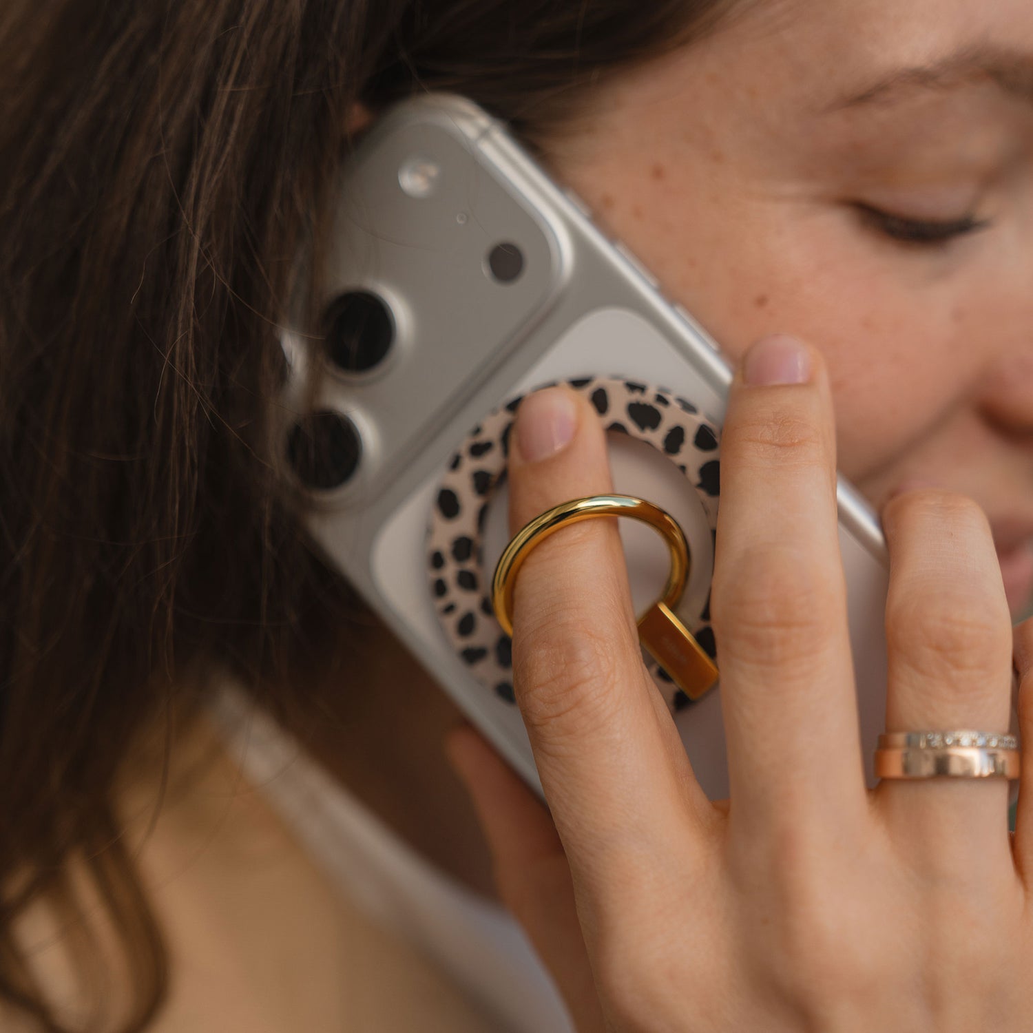 Eine Frau hält den arktis Magnetischer Ringhalter für MagSafe - Sweet Leopard, der mit seinem stylischen Leoparden-Print-Design und der starken N52 Magnete elegantes iPhone Zubehör zur Schau stellt.
