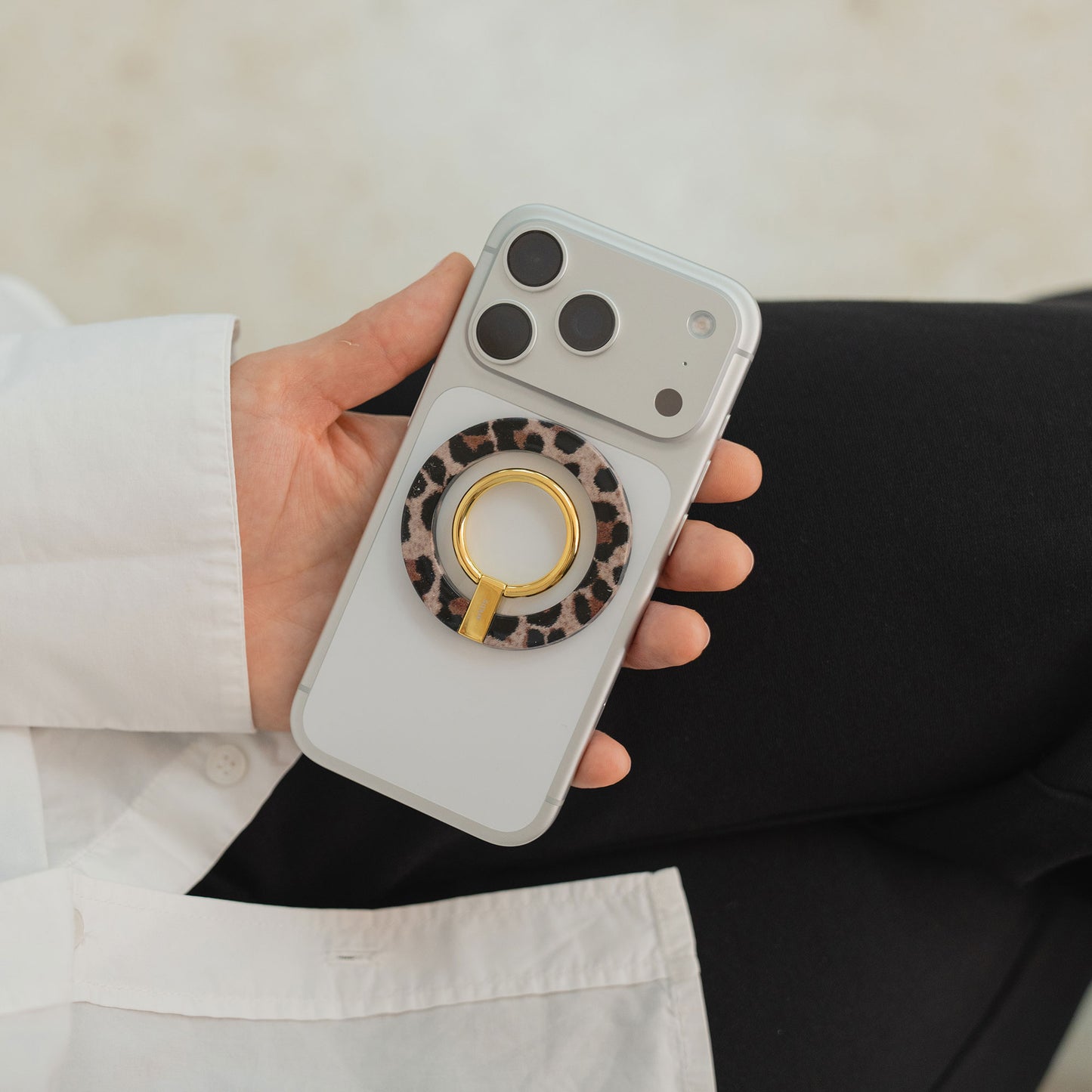 Eine Hand hält einen arktis Magnetischer Ringhalter für MagSafe - Sweet Leopard auf einem weißen iPhone-stylischen Zubehör mit starken N52 Magneten für sicheren Halt und einfache Befestigung.