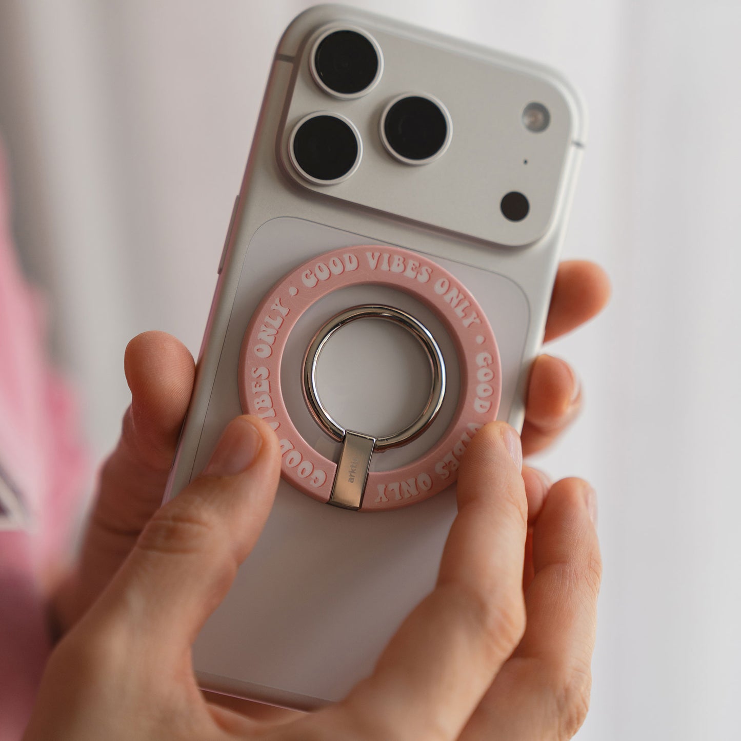 Eine Hand hält ein Telefon mit dem arktis Magnetischer Ringhalter für MagSafe - Good Vibes, der Stil und Komfort für dein iPhone Zubehör vereint.