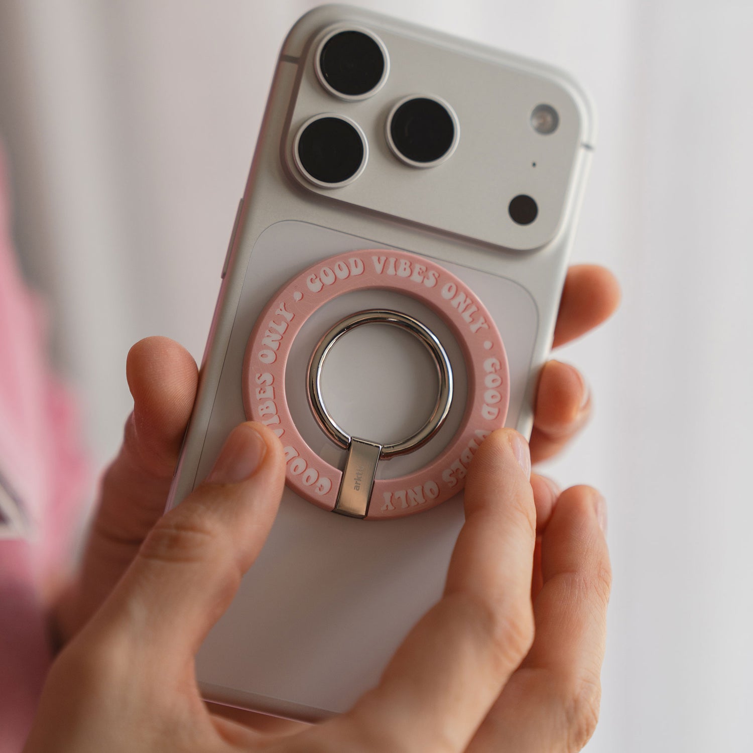 Eine Hand hält ein Telefon mit dem arktis Magnetischer Ringhalter für MagSafe - Good Vibes, der Stil und Komfort für dein iPhone Zubehör vereint.