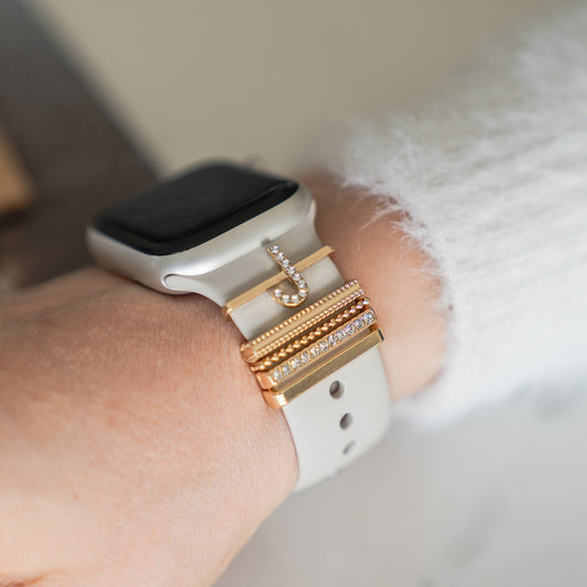 Die Arktisband Apple Watch Charms „J Style“ verleihen Ihrem weißen Arktisband goldene und diamantene Akzente und sorgen so für einen extravaganten Look an Ihrem Handgelenk.
