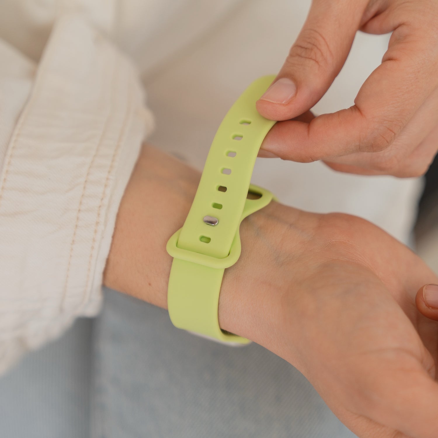 Das arktisband Apple Watch Silikonarmband "Sport" in hellgrün von arktisband wird von einer Person am Handgelenk befestigt und ist somit ideal als schweißabsorbierendes Armband für Alltag und Sport.