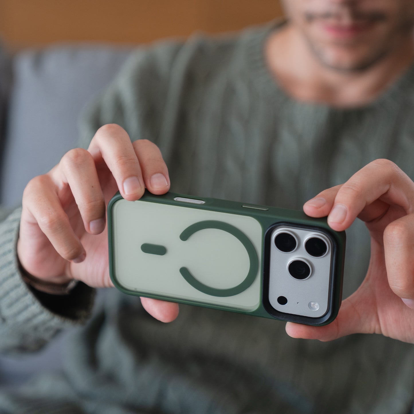 Person hält ein Smartphone mit der Arktis iPhone 17 Pro Solid Case mit MagSafe, einer grünen, matten Schutzhülle von Arktis, die die MagSafe-Kompatibilität und die Kamerafunktionen der iPhone 17 Pro Hülle präsentiert.
