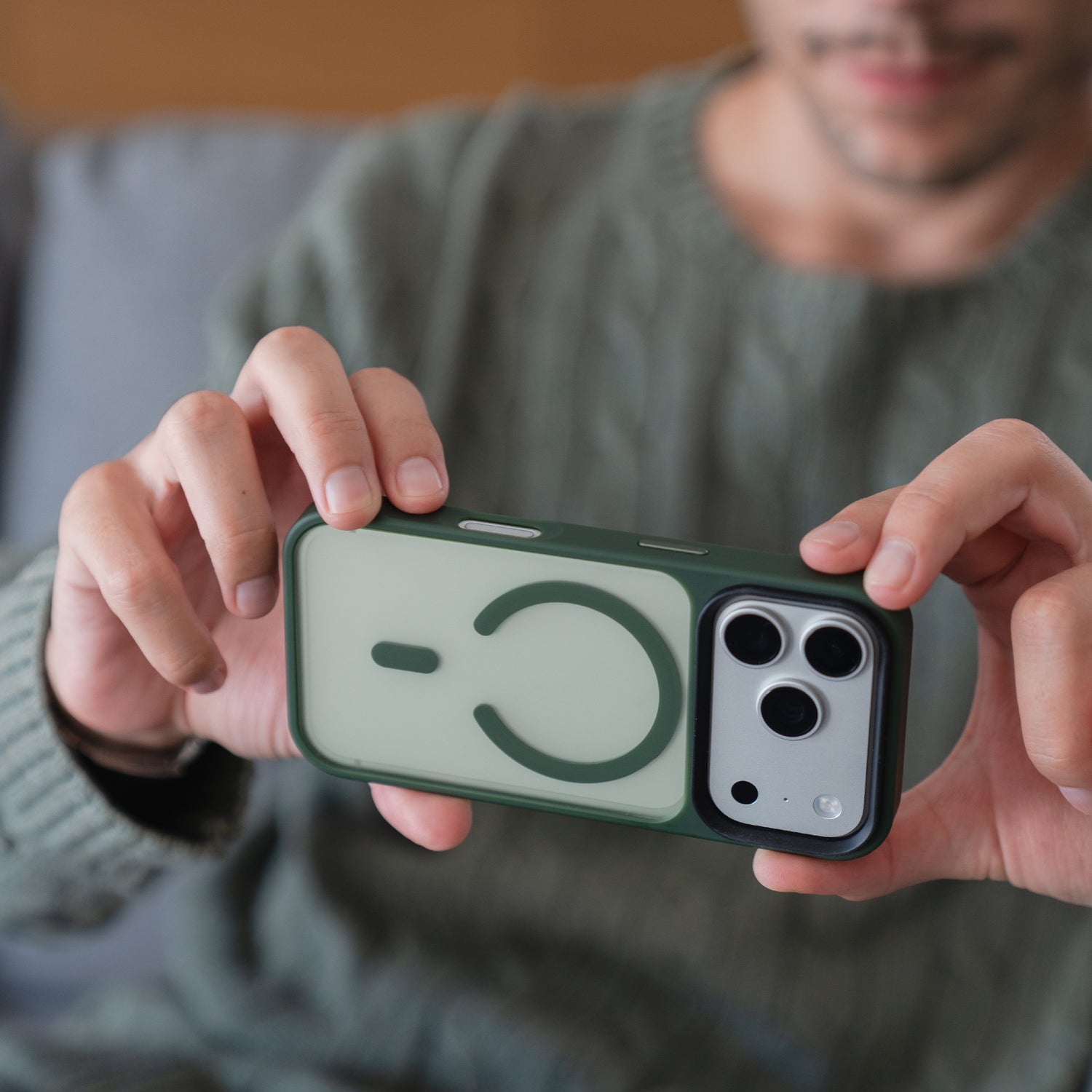Person hält ein Smartphone mit der Arktis iPhone 17 Pro Solid Case mit MagSafe, einer grünen, matten Schutzhülle von Arktis, die die MagSafe-Kompatibilität und die Kamerafunktionen der iPhone 17 Pro Hülle präsentiert.