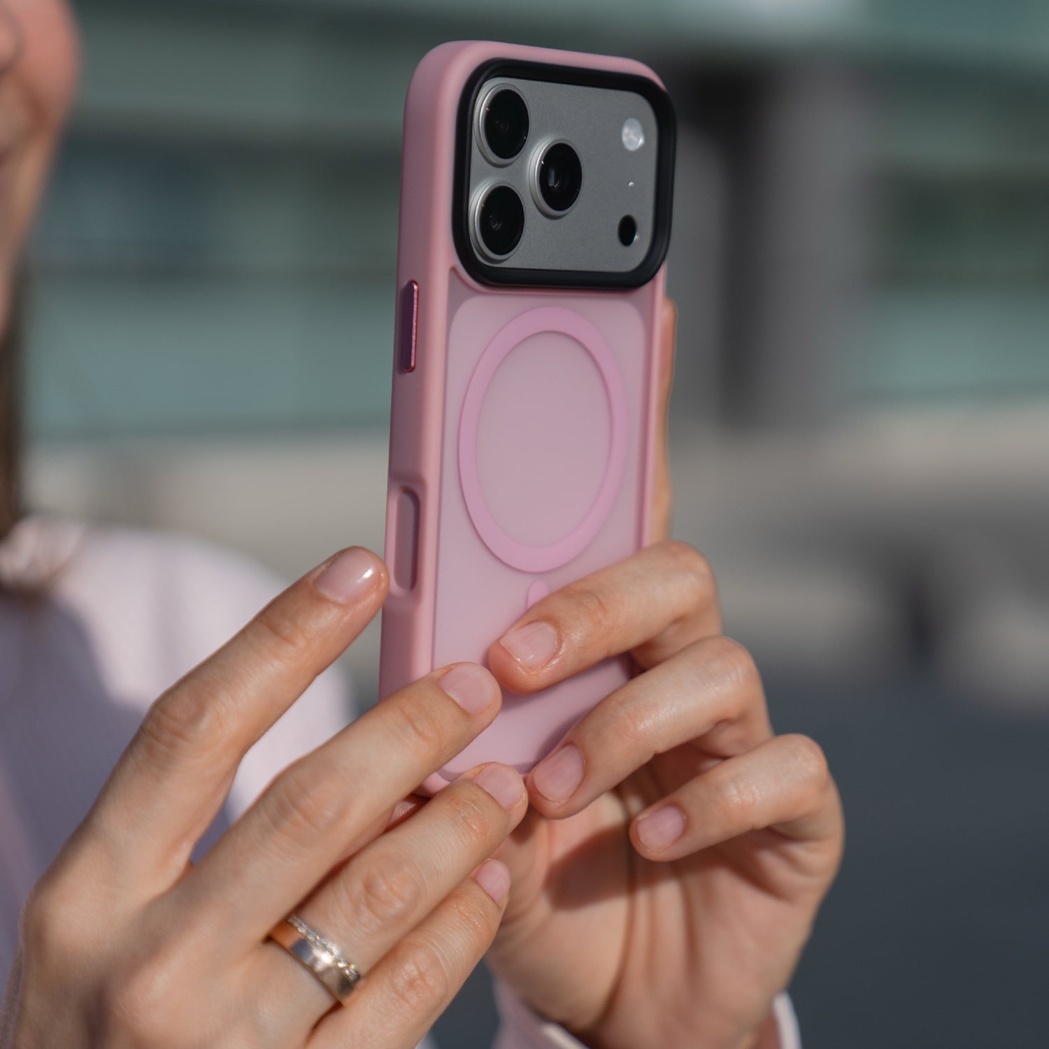 Eine Person hält die Arktis iPhone 17 Pro Solid Case mit MagSafe, eine rosafarbene, matte Schutzhülle von Arktis, und konzentriert sich auf die Kamera des Telefons.