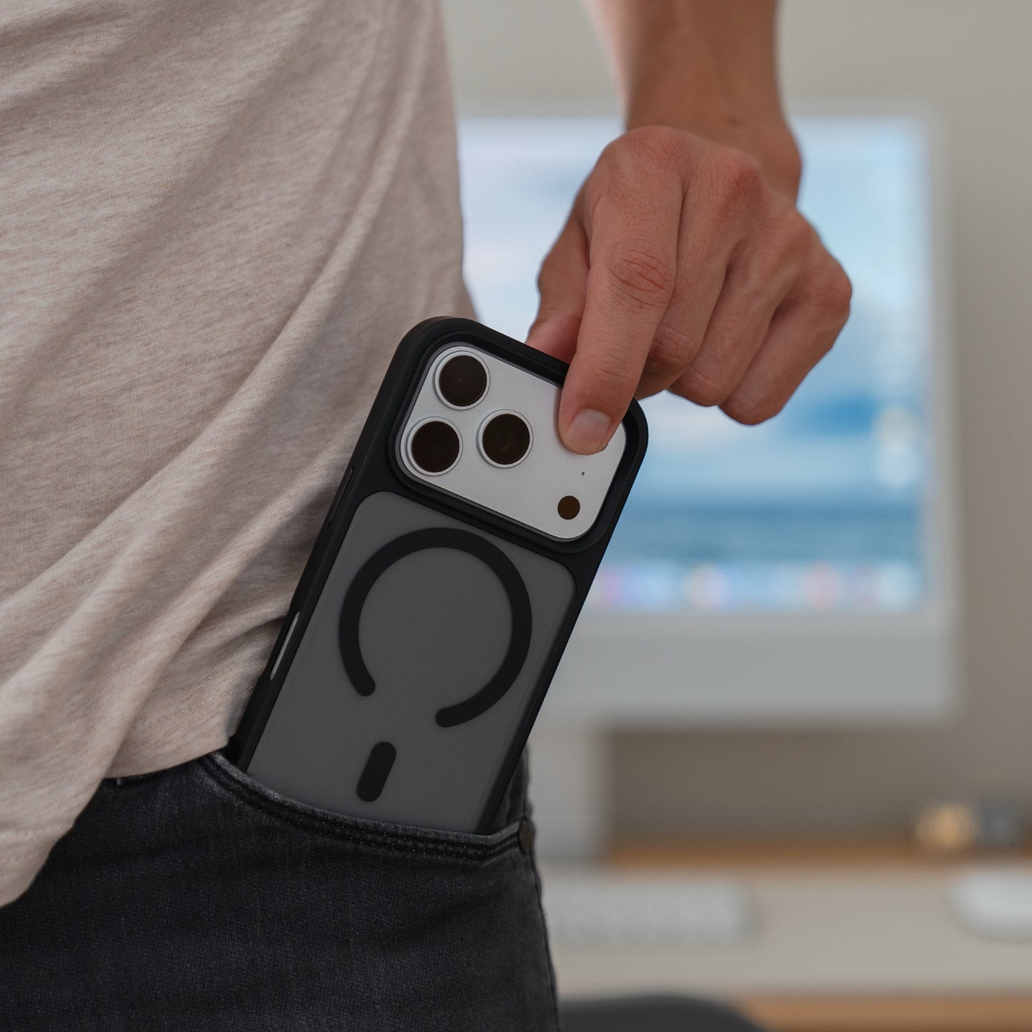 Eine Person steckt ein Arktis iPhone 17 Pro Solid Case mit MagSafe, eine matte Schutzhülle von Arktis, in die Vordertasche ihrer Jeans.