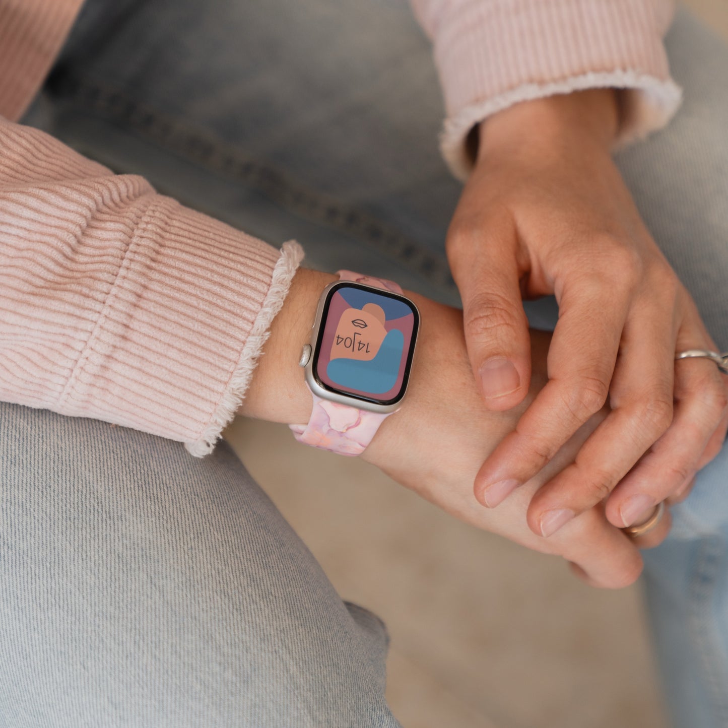Eine Person trägt ein arktisband Rose Marble Apple Watch Armband von arktisband mit einer Herzgrafik auf dem Bildschirm der Smartwatch.