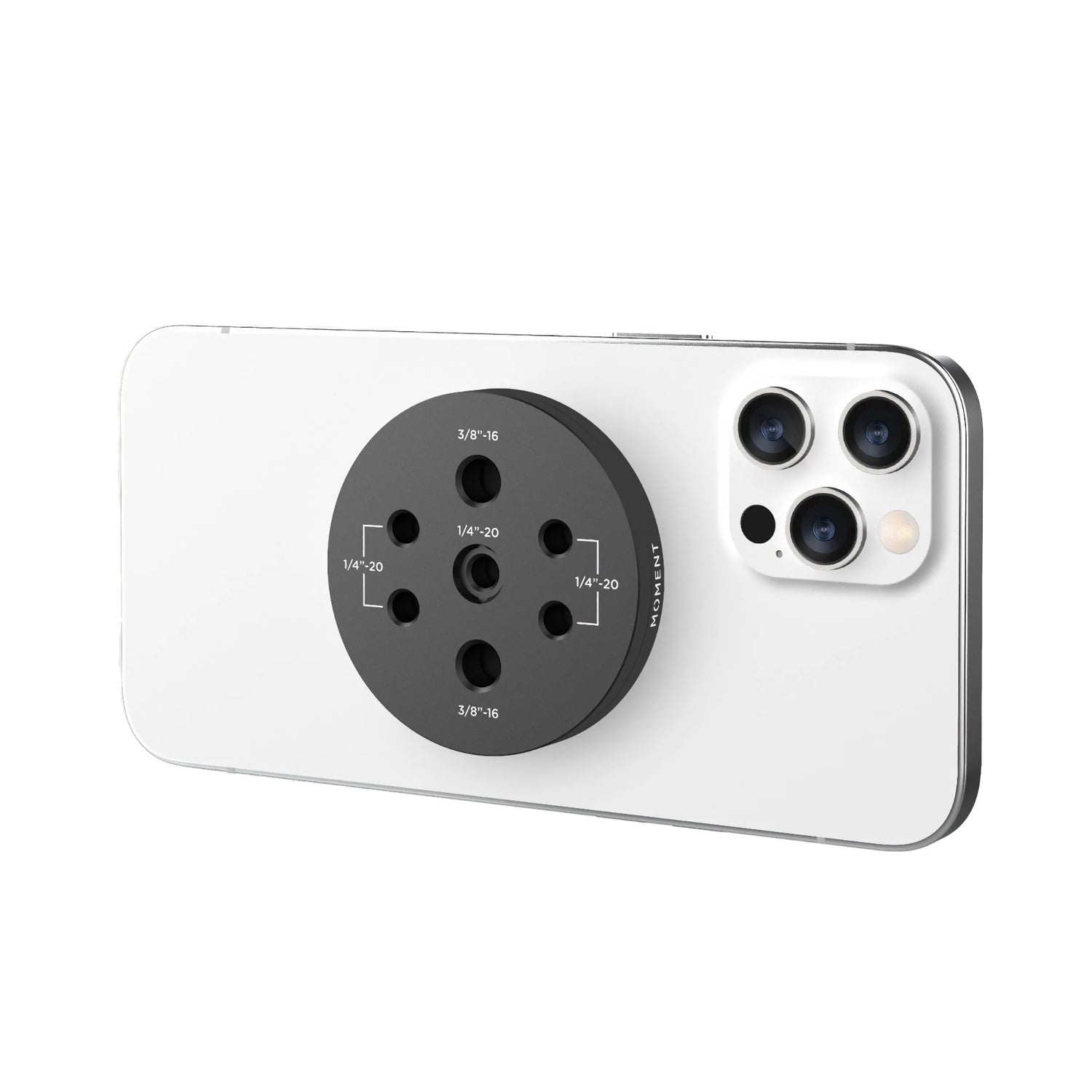 Die MOMENT Moment Multi Threaded Mount für MagSafe ist eine schwarze kreisförmige Halterung, die an einem weißen Smartphone befestigt wird, perfekt für mobiles Filmemachen und das Einrichten des eigenen iPhone Filmstudios.