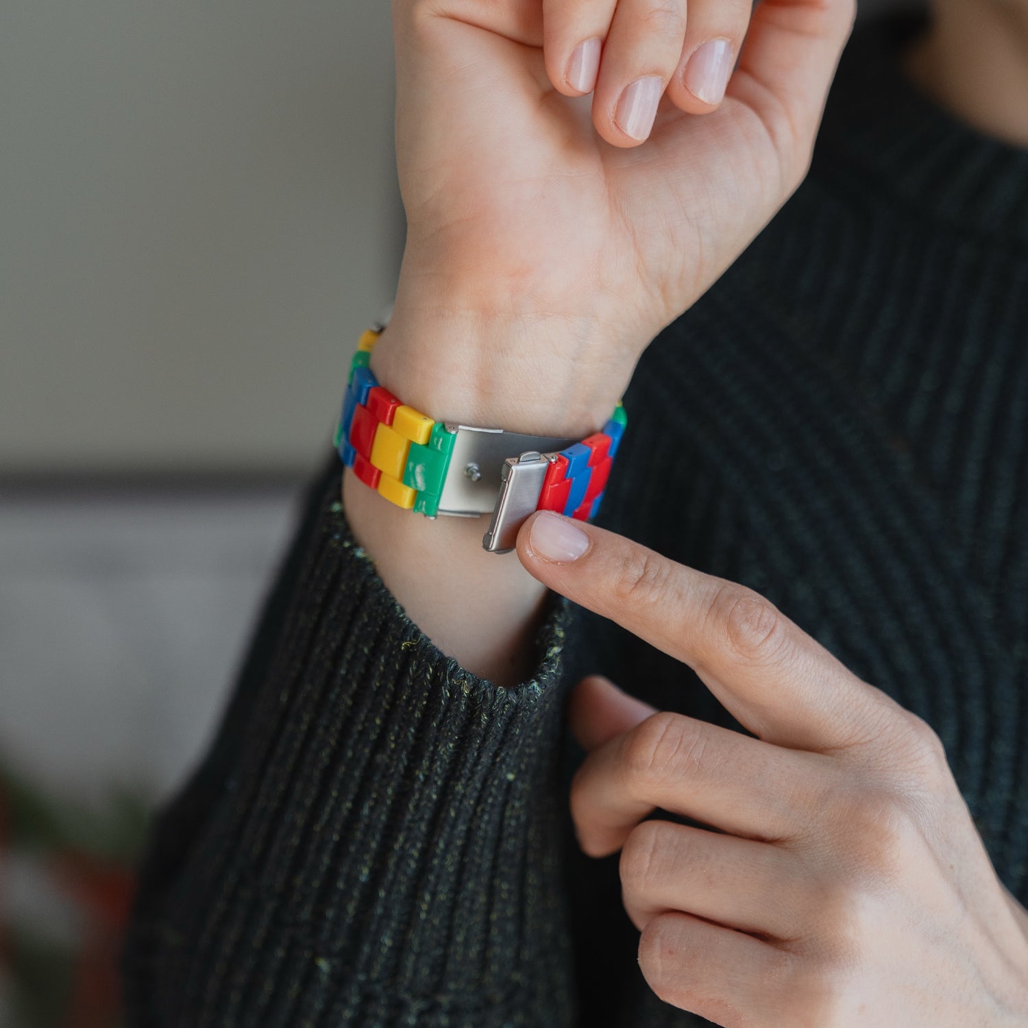 Eine Person trägt das arktisband Apple Watch "Pixel Band", ein buntes Armband im LEGO-Stil von arktisband, das einen verspielten Retro-Look an ihrem Handgelenk präsentiert.