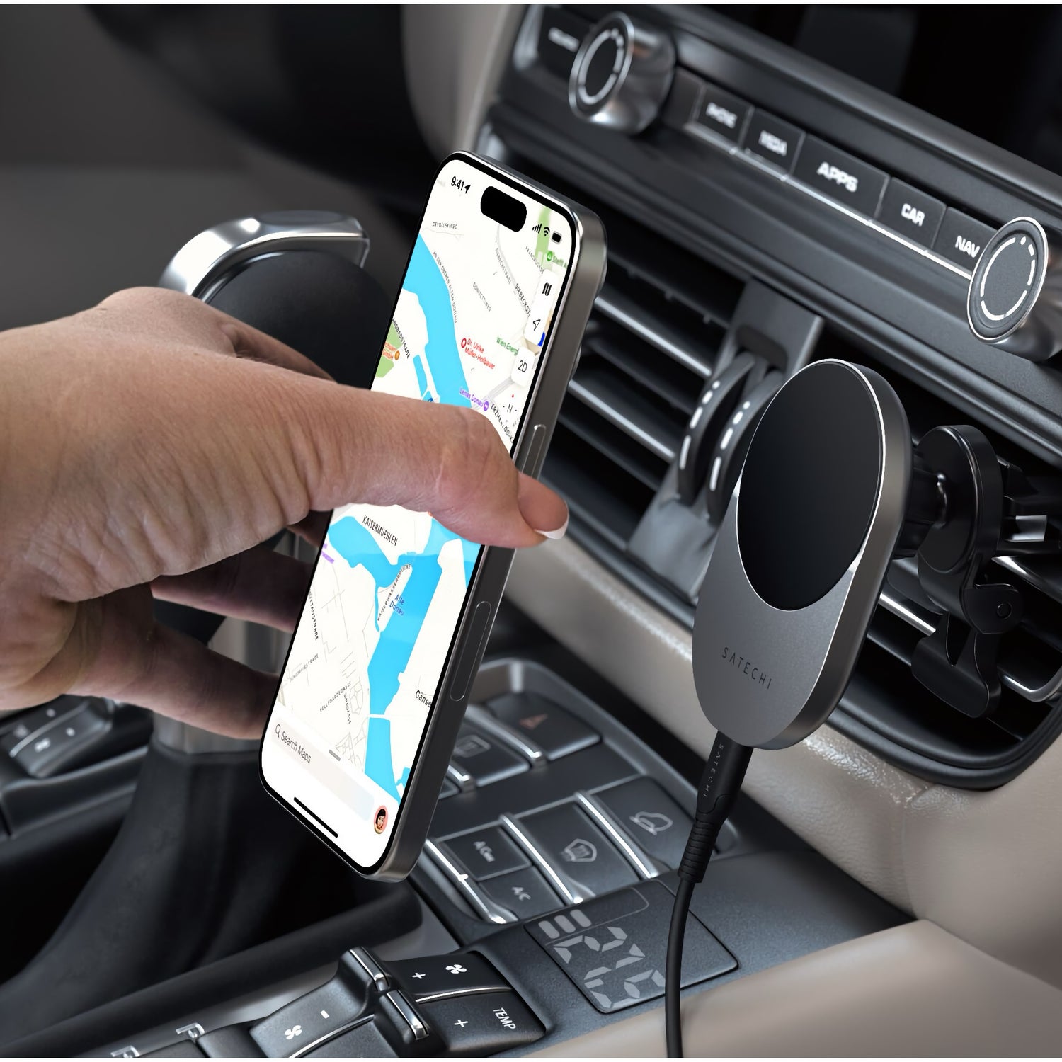 Eine Hand legt ein Smartphone mit einer Karten-App auf das Satechi Qi2 Magnetic Wireless Car Charger von Satechi, das MagSafe-kompatibel ist und zum kabellosen Aufladen einfach an der Lüftungsöffnung Ihres Autos befestigt wird.