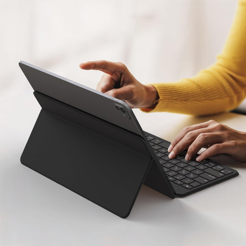 Eine Person benutzt eine Satechi OntheGo Bluetooth-Tastatur mit Ständer, tippt mit einer Hand und tippt mit der anderen auf den Tablet-Bildschirm, während ihr Gerät über ein Qi2 Magnetic Wireless Car Charger mit Strom versorgt wird.
