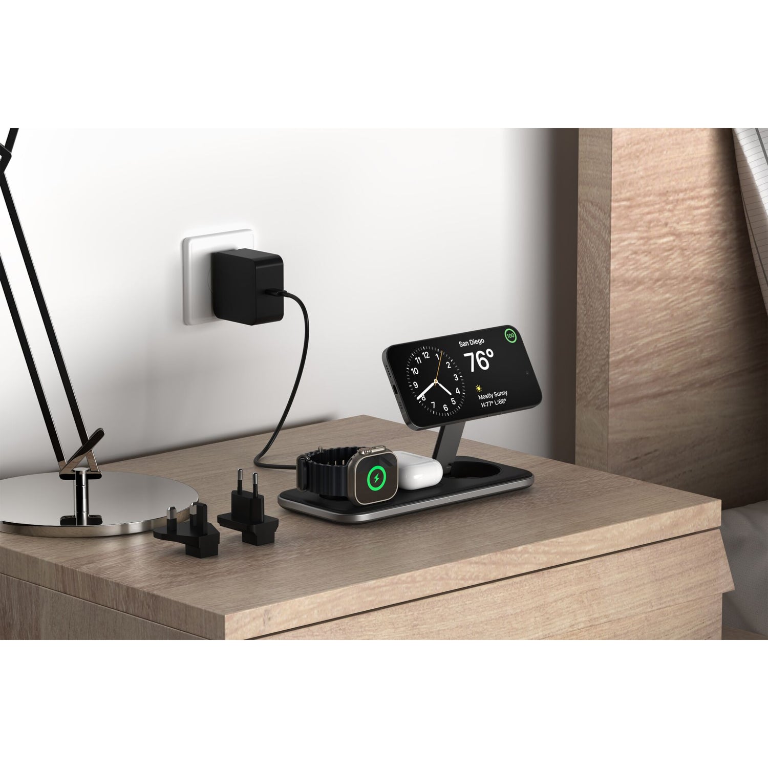 Das Satechi Qi2 Trio Wireless Charging Pad liegt auf dem Nachttisch und lädt ein Telefon, eine Smartwatch und Ohrstöpsel neben Steckern und einer Lampe auf - und liefert mühelos kabellosen Strom von Satechi.