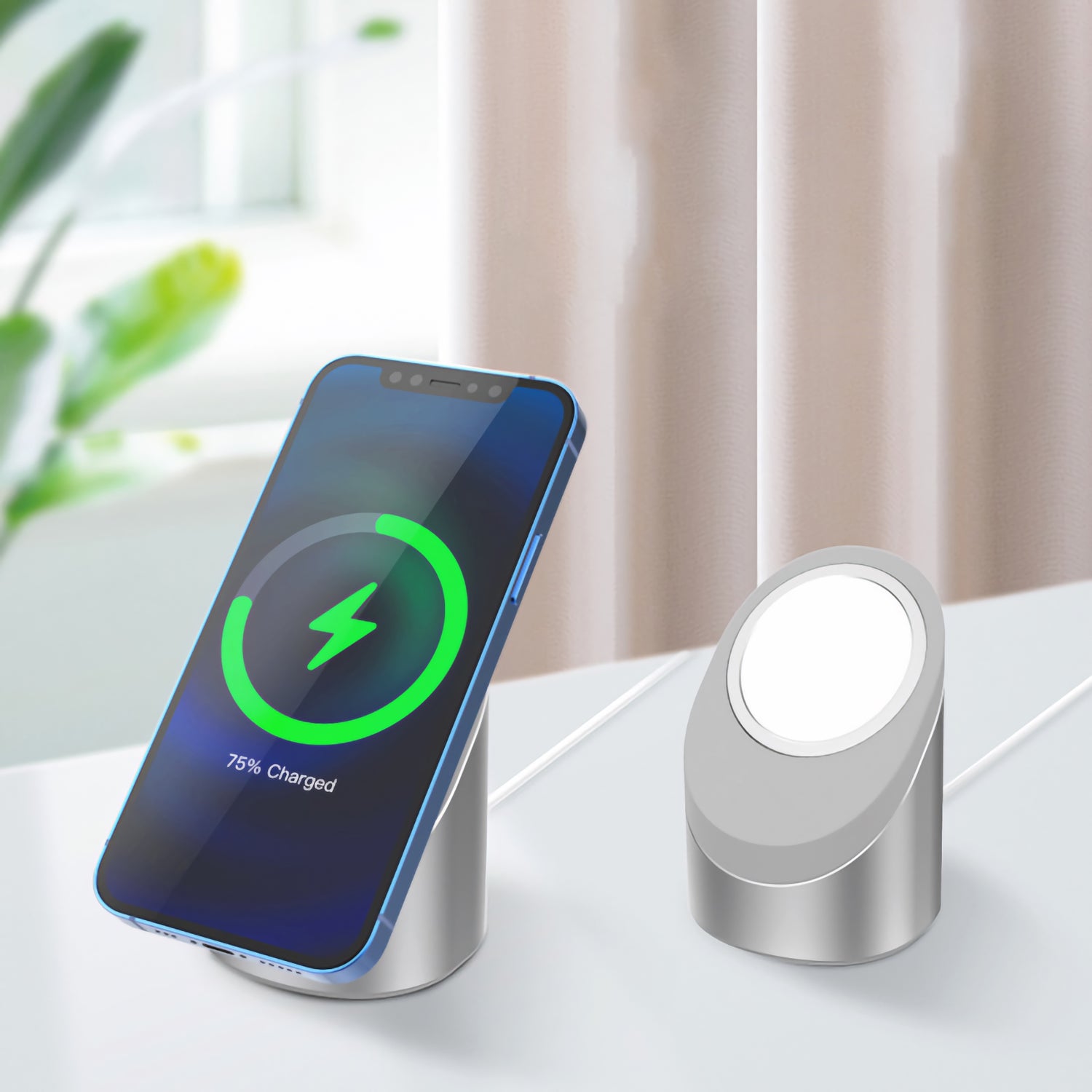 Ein arktis Smartphone wird kabellos auf einem silbernen arktis MagSafe NightStand neben einer leeren, passenden iPhone Ladestation aufgeladen, die beide auf einer weißen Fläche liegen.