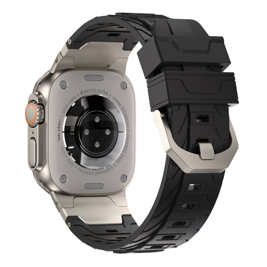 Eine Nahaufnahme des Arktisband Apple Watch Ultra Armbands „Orbiter“ zeigt die Rückseite einer Apple Watch Ultra mit silbernem Gehäuse, Sensor-Array und einem schwarzen FKM-Kunststoff-Sportarmband mit Metallschließe. Technische Details sind rund um den Sensorbereich eingraviert.